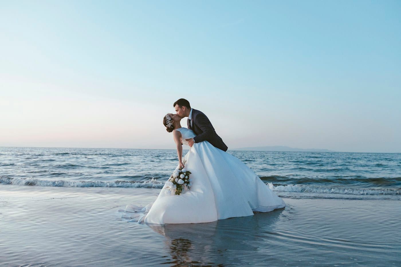 Noivos se beijando à beira-mar (foto ilustrativa)