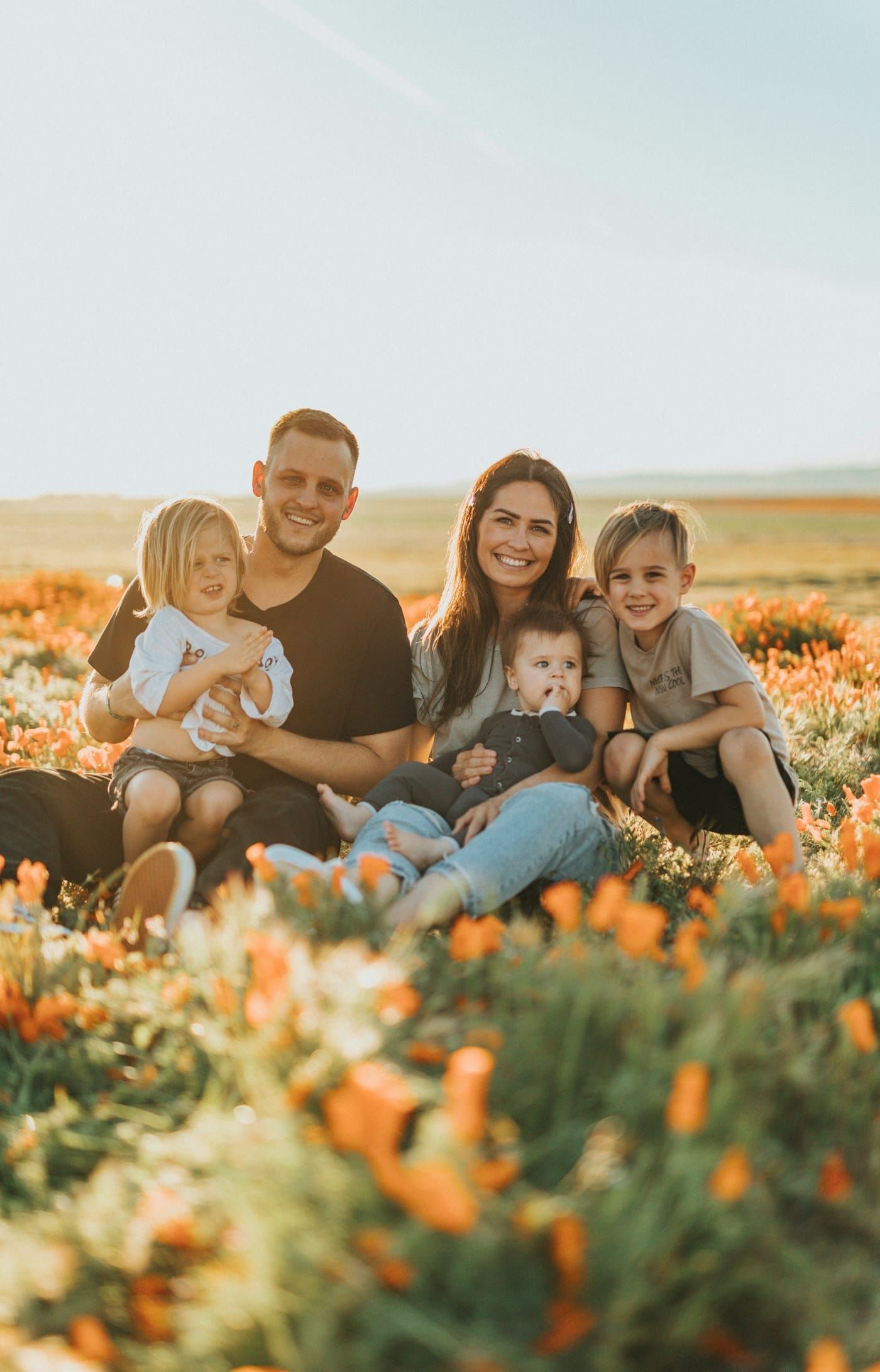Família sorrindo em campo de flores (foto ilustrativa)