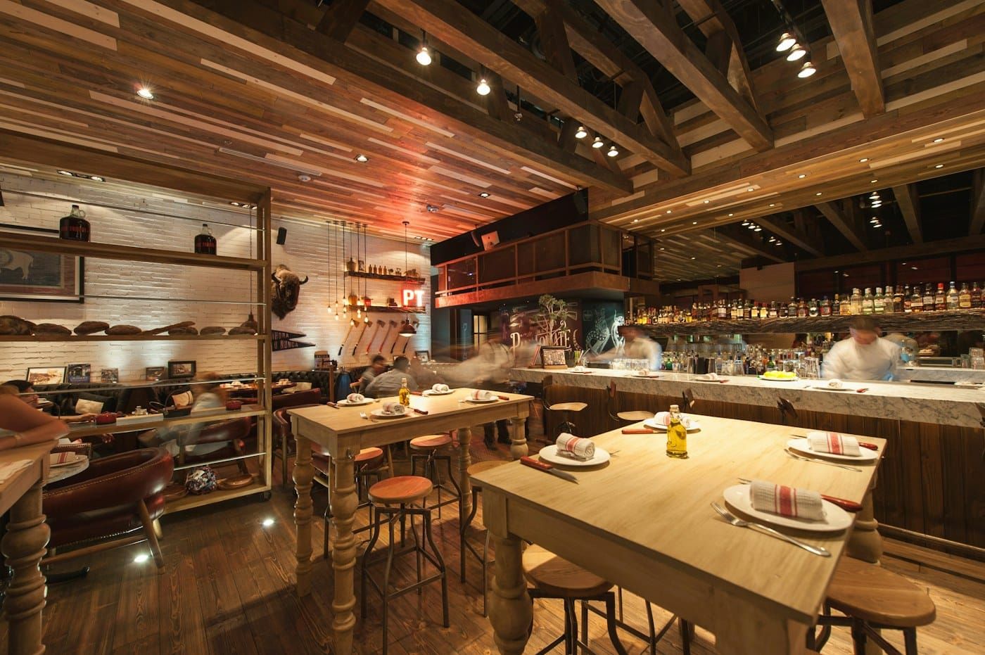 Salão do restaurante com mesas de madeira (foto ilustrativa)