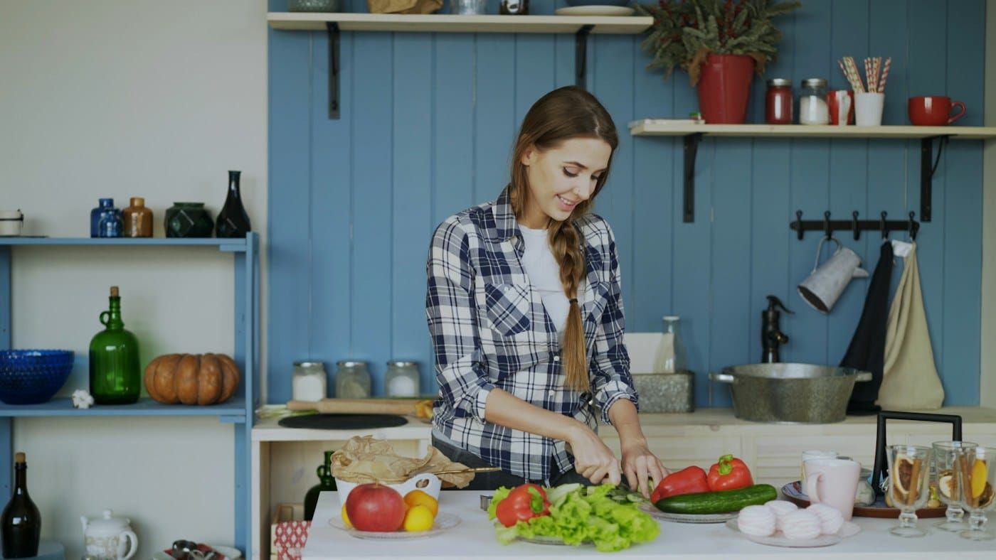 Cozinheira preparando legumes na cozinha (foto ilustrativa)
