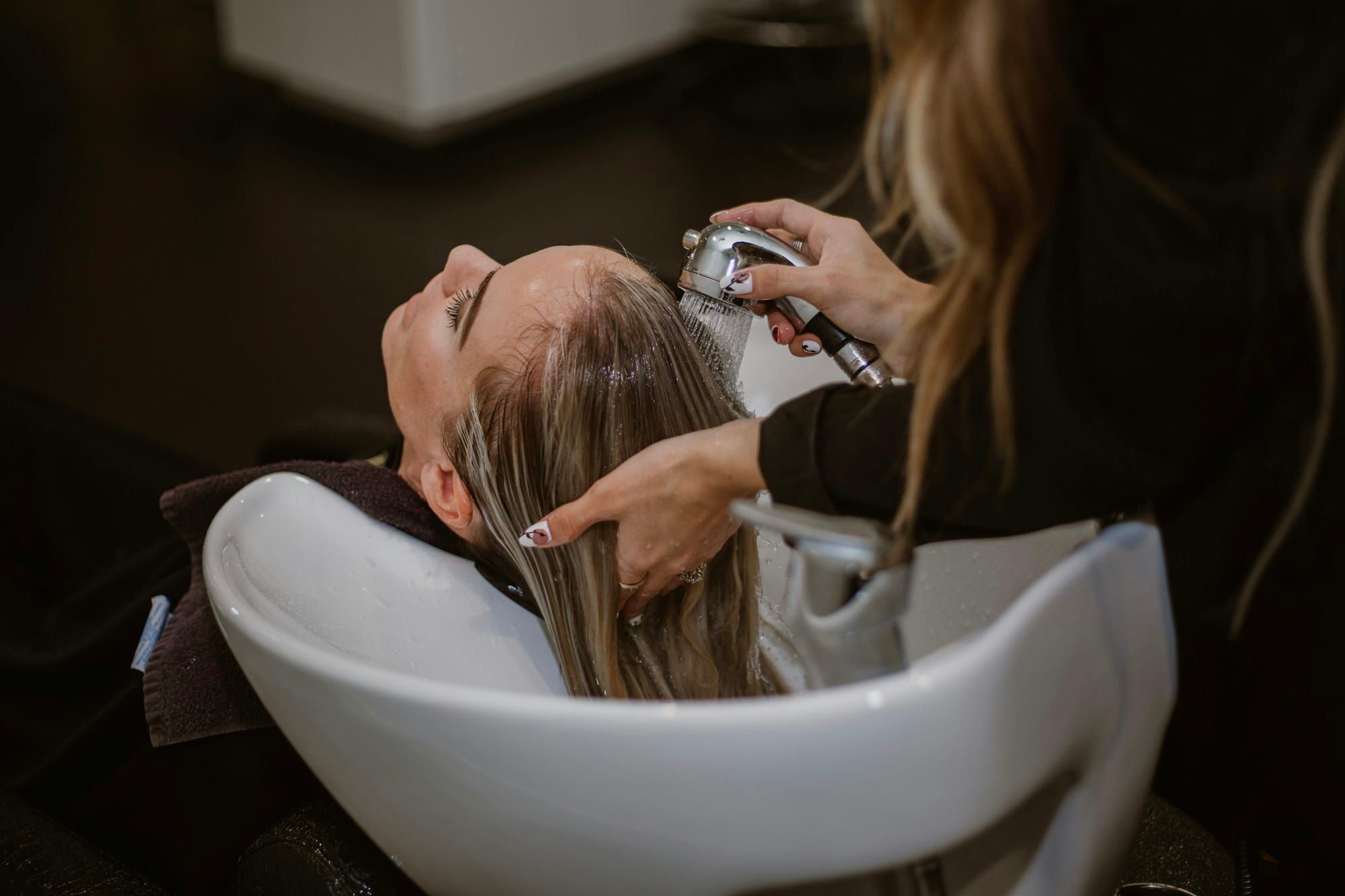 Cabeleireira lavando o cabelo de uma cliente (foto ilustrativa)